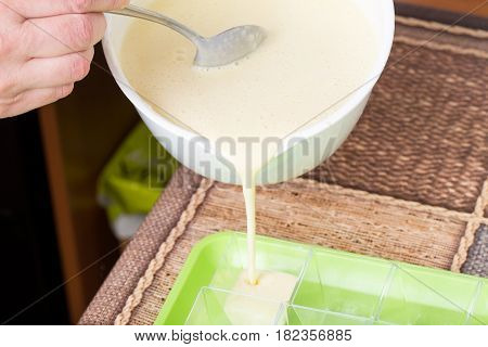 Pouring dough into plastic baking forms. Macro. Photo can be used as a whole background.