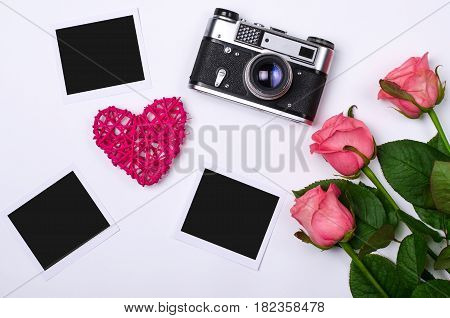Old Vintage Photo Camera And Pink Roses On A White Background.