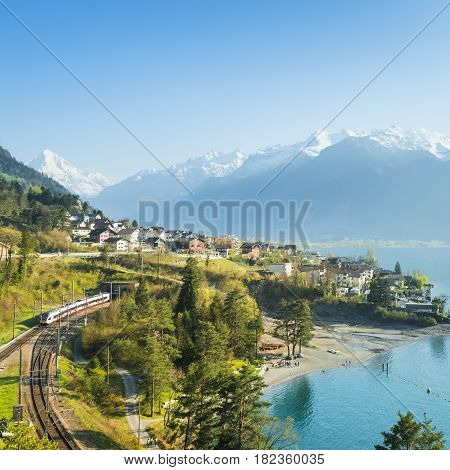 View of the small town in the Alps mountains. Railway along Lake Lucerne. Canton of Uri.