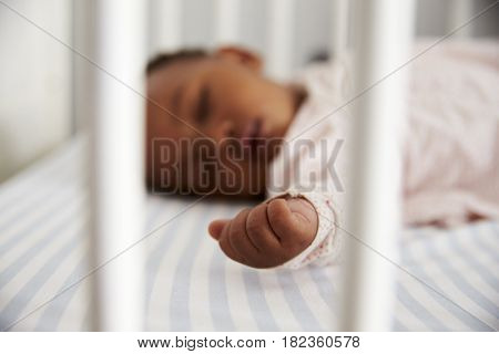 Close Up Of Baby Girl Sleeping In Nursery Cot