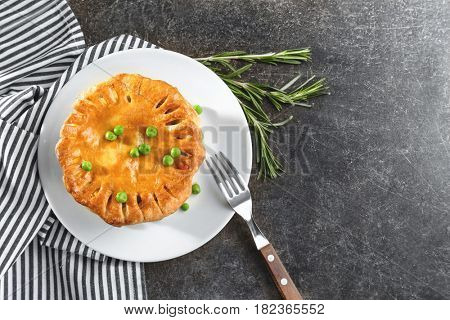 Tasty chicken pot pie with green peas on kitchen table