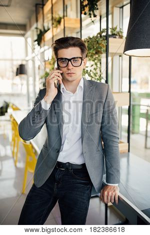 Young Businessmen Working In His Office And Speaking On His Mobile Phone.