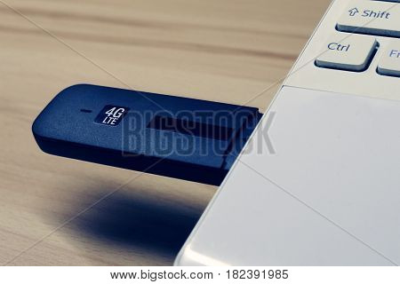 USB modem LTE 4G connected to laptop, shallow depth of field, tonned photo