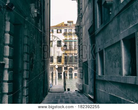 Narrow passage in Venice streets leading to water