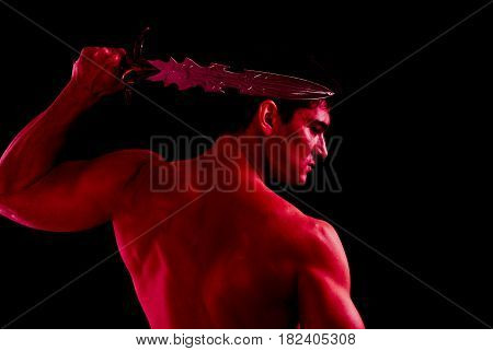 The tough warrior is holding his sword.