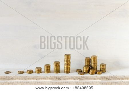 Golden coins stacks arranged as a graph on a wooden background. Business growth and Saving money concept