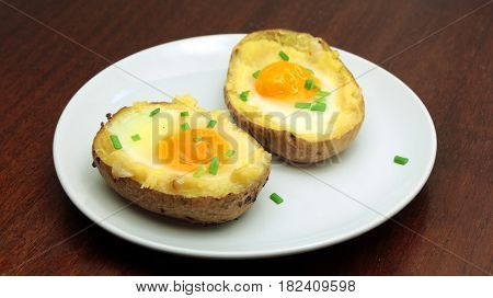 Twice baked potatoes with egg on top on white plate
