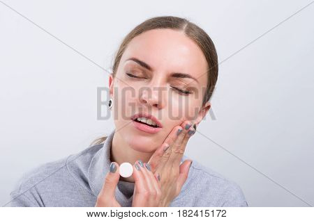 Attractive girl taking a pill on light background. Healthcare concept.