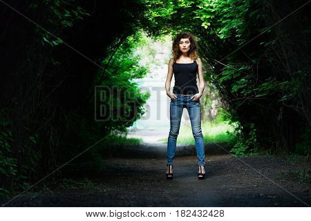 Portrait of a girl in a black shirt. Summer. Green trees.