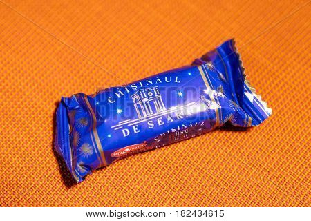 PARIS FRANCE - APR 9 2017: Chisinaul de Seara BUCURIA candy produced in Republic of Moldova against red textile background