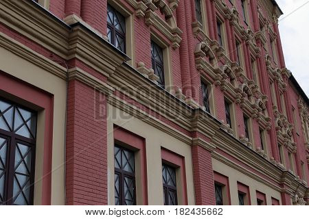 Facade of an old and beautiful building. Arched windows. View at an angle.