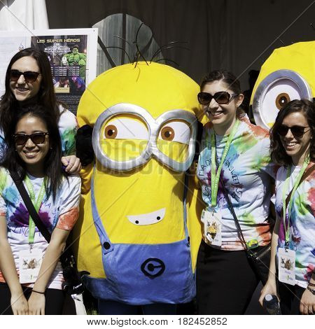 Laval, Quebec - June 14, 2015 - Square view of a large group girls posing with a costumed Minion at the 