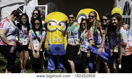 Laval, Quebec - June 14, 2015 - Landscape view of a large group girls posing with a costumed Minion at the 
