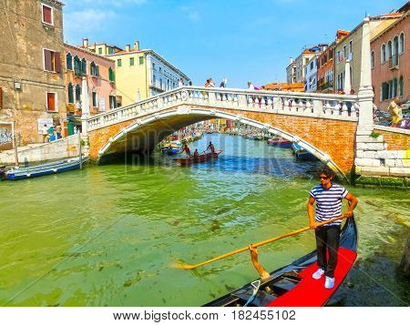 Venice, Italy - June 06, 2015: Unidentified man rows gondola on June 06, 2015 in Venice, Italy. Venice is situated across a group of 117 small islands that are separated by canals and linked by bridges.
