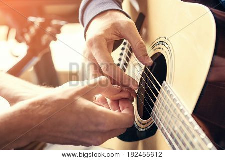 Masterclass learning to play the guitar outdoors. Musical education.