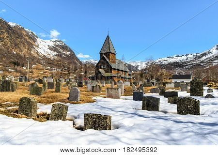 Roldal Stave Church (Roldal stavkyrkje) with snow graveyard foreground Norway