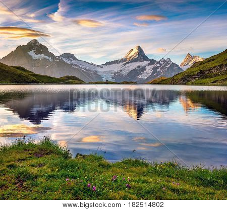 Wetterhorn and Wellhorn peaks reflected in water surface of Bachsee lake. Colorful summer sunrise in Bernese Oberland Alps Grindelwald location Innertkirchen Switzerland Europe.