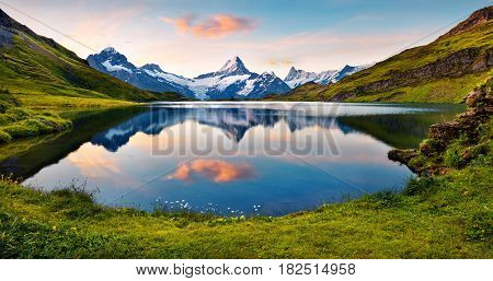 Wetterhorn and Wellhorn peaks reflected in water surface of Bachsee lake. Colorful summer sunrise in Bernese Oberland Alps Grindelwald location Innertkirchen Switzerland Europe.