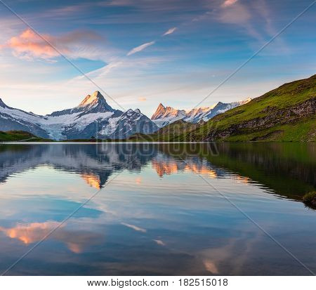 Wetterhorn peak reflected in water surface of Bachsee lake. Colorful summer sunrise in Bernese Oberland Alps Grindelwald location Innertkirchen Switzerland Europe.