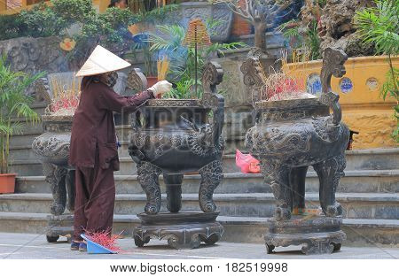 HANOI VIETNAM - NOVEMBER 22, 2016: Unidentified woman cleans at Quan Su Temple. Quan Su Temple was built in the 15th century under the Le Dynasty.