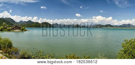 Panoramic view at the Montenegro part of Skadar mountain lake travel destination. Sunny day and blue sky with clouds. Skadar lake is a national park nature place on Montenegro, Europe