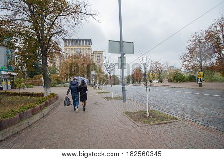 Kiev Ukraine - September 08 2016: Couple under an umbrella on an empty street Institutskaya