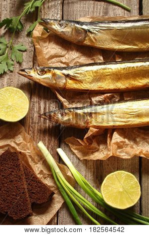Fish saury smoked on paper and wooden boards