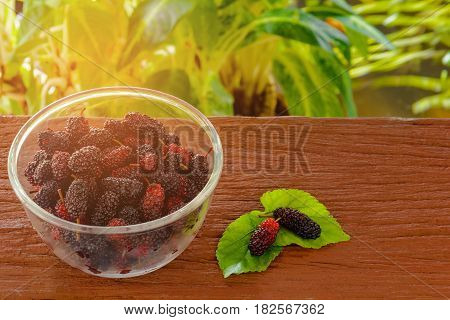 Mulberry in glass cup on wooden table
