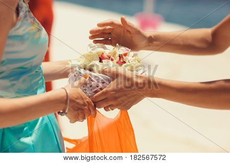 Man takes a palte with petals from woman's hands