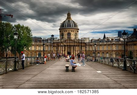 View on facade of Institut de France in Paris from Pont des Arts at cloudy day