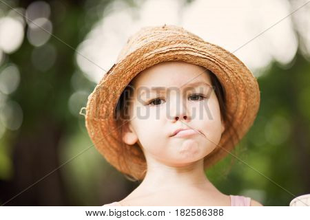 Girl in a straw hat in the park