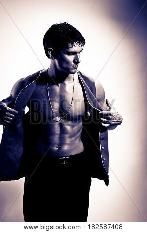 the sexy man is undressing his shirt.
