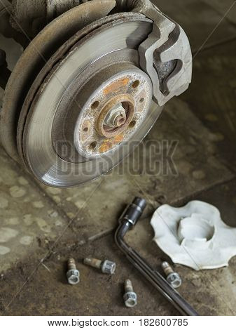 The rear of the car in the garage with the removed wheel. Replacement rear wheel vehicle mechanic in the garage.
