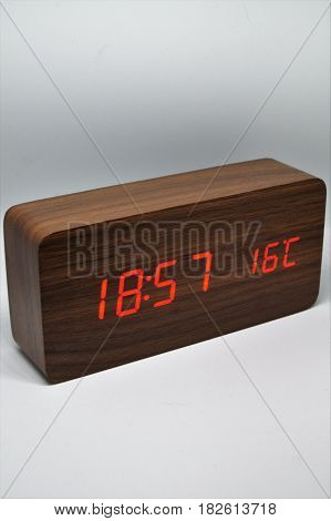 Digital wooden alarm clock marking the time and the temperature