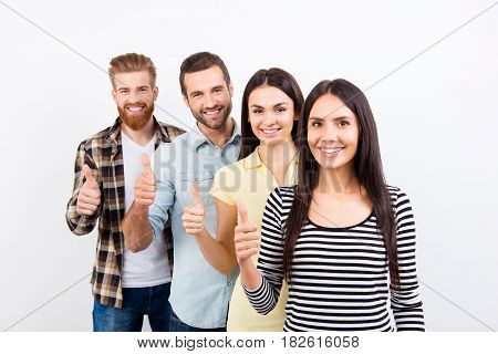 Four Happy Successful  Young Prople Are Showing Thumbs Up On White Background In Casual Clothes And