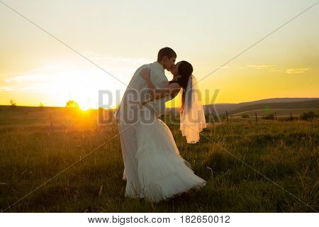 Wedding couple is dansing on the sunset