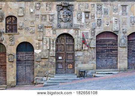 Coats of arms and heavy doors on the facade of Palazzo Pretorio - Arezzo, Italy