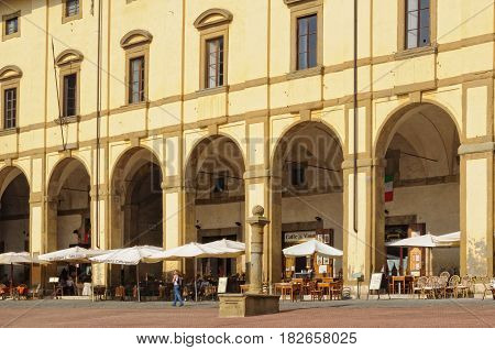 Cafes and restaurants under the yellow facade and elegant arches of Loggia del Vasari - Arezzo, Italy, 24 September 2011