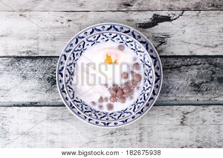 Purple Potato Dumplings With Poached Egg And Coconut Roll In Sweet Coconut Cream .