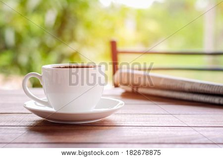coffee cup with newspaper on the table at home warm tone