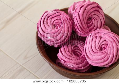 Currant zephyr or marshmallow in ceramic bowl on wooden background.