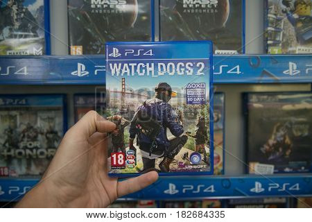 Bratislava, Slovakia, circa april 2017: Man holding Watch Dogs 2 videogame on Sony Playstation 4 console in store