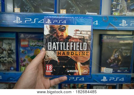 Bratislava, Slovakia, circa april 2017: Man holding Battlefield hardline videogame on Sony Playstation 4 console in store