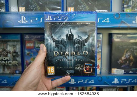Bratislava, Slovakia, circa april 2017: Man holding Diablo 3 Reaper of Souls Ultimate Evil Edition videogame on Sony Playstation 4 console in store
