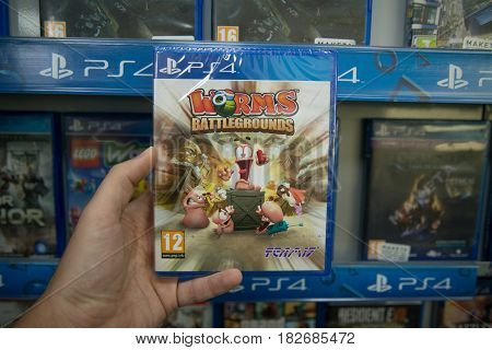 Bratislava, Slovakia, circa april 2017: Man holding Worms Battlegrounds videogame on Sony Playstation 4 console in store