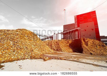 Bio Power Plant With Storage Of Wooden Fuel Against Blue Sky