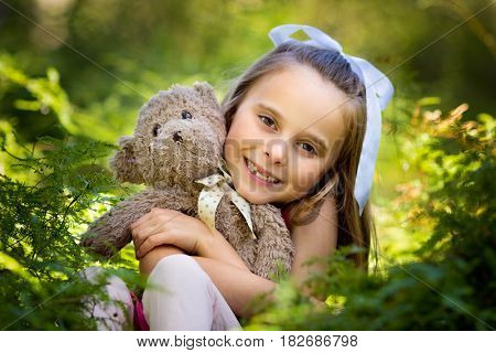 Pretty smiling girl holding teddy bear