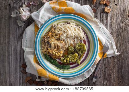 Pasta with chicken and vegetables on a dark wood in a rustic style