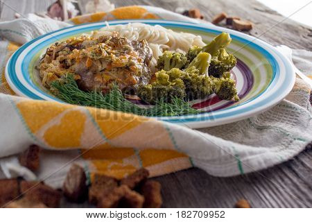 Pasta with chicken and vegetables on a dark wood in a rustic style