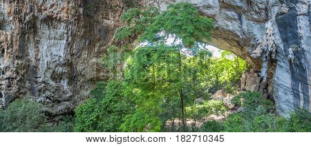 aerial photography above amazing cave. Tham Than Lod Yai is the big cave and have one hole on the top of the cave. it is a short cave there have waterfall pass inside through to another cave
